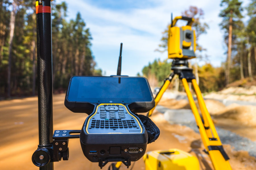 surveyors equipment on the construction site of the road or building with construction machinery background