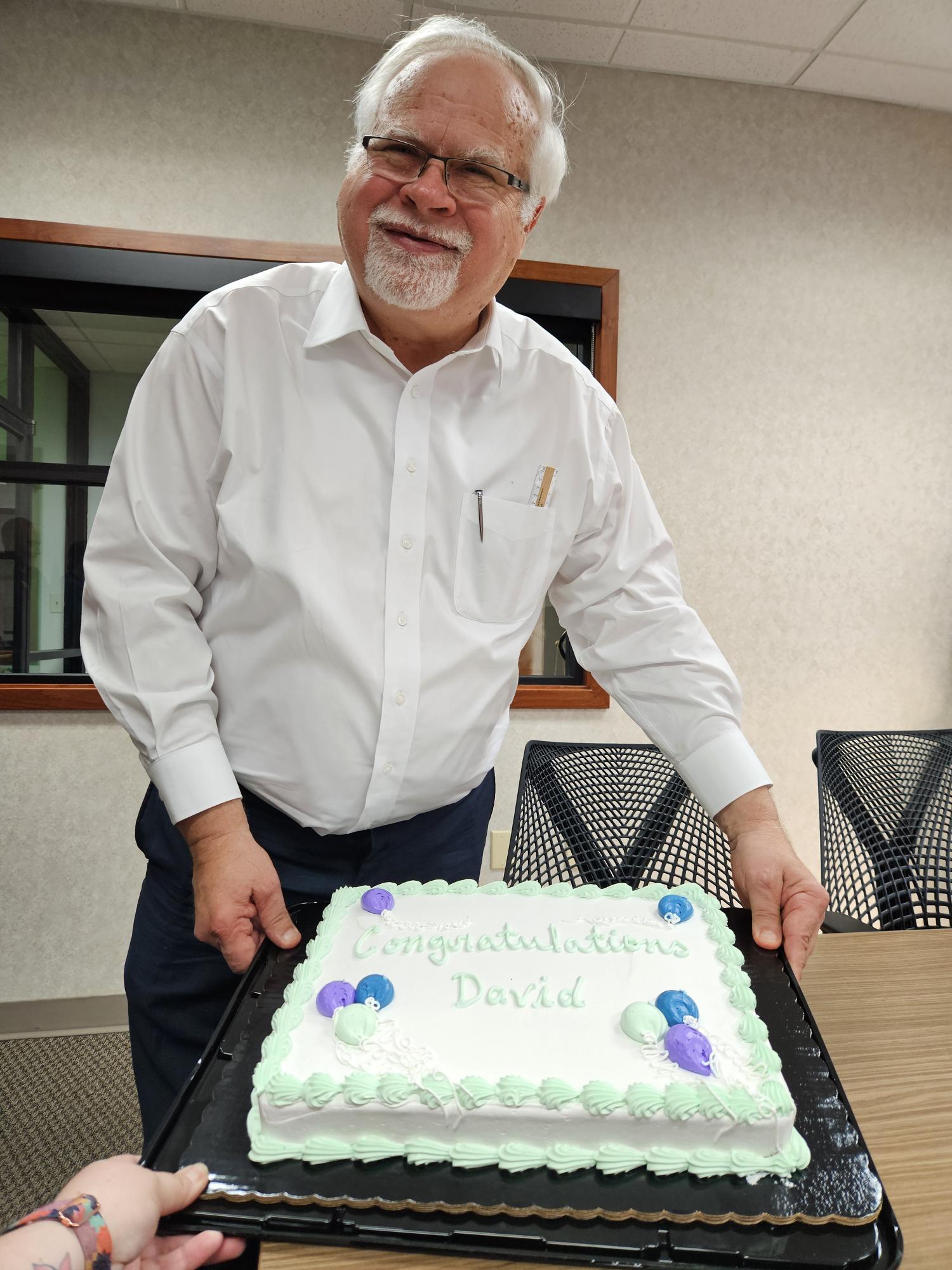 David Mindel holding up celebratory cake
